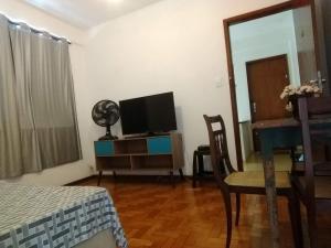 a living room with a tv and a table and a desk at Apartamento ótima localização, próximo a avenida, situado no 3 pavimento em prédio sem elevador in Teresópolis
