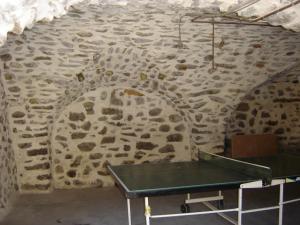 a ping pong table against a stone wall at Appartement La Petite Cascade in Allos