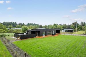 una casa nera con un grande prato davanti di JB350-Fjerritslev-Egevej-9 a Fjerritslev