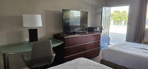 a hotel room with a desk and a tv and a bed at Sunrise Inn in Eastman