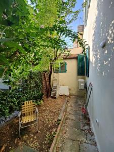 a chair and a tree next to a building at Discover Donatello - Fiorenza in Florence