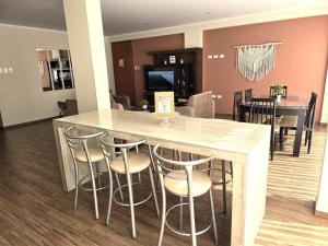 cocina y comedor con mesa y taburetes en Departamento Céntrico en Primer Piso, en Tacna