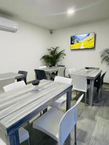 a dining room with wooden tables and white chairs at Casa Love Us in Tequisquiapan
