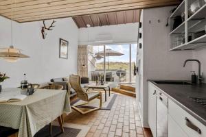 a kitchen and living room with a table and chairs at JB358-Brovst-Strandvejen-150-Lejl-126 in Tranum Strand