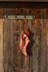 an orange and white purse hanging on a wooden wall at Wallerei Walchensee in Walchensee