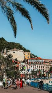 Spacious 3 room close to tram and amenities في نيس: مجموعة من الأشخاص يقفون أمام مبنى