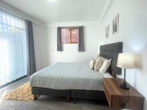 a bedroom with a bed and a table with a lamp at Rural Retreat with Charming Patio 2 Bedrooms in Urubamba