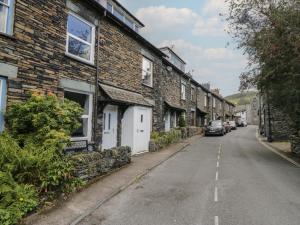 eine leere Straße in einem Dorf mit Backsteinhäusern in der Unterkunft Cloud Cottage in Ambleside