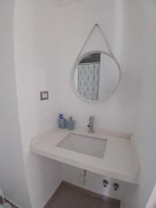une salle de bain avec un lavabo blanc et un miroir dans l'établissement departamento cómodo y central, à Santiago 11 autres photos