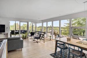 a living room with a couch and a table and chairs at JB400-Brovst-Solsortevej-7 in Tranum