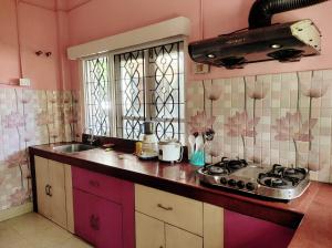 y cocina con fregadero y fogones. en El Dorado Inn, en Guwahati