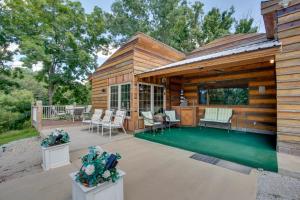 a wooden cabin with a patio with chairs and tables at Bayview - Lakefront Family Cabin in Odessa! in Odessa