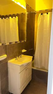 une salle de bain avec un lavabo, un miroir et une baignoire dans l'établissement Los Soles de Madryn, à Puerto Madryn