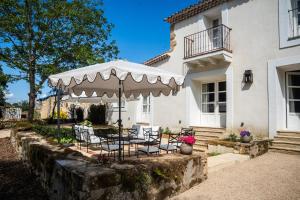una mesa y sillas bajo una sombrilla frente a una casa en Los Sauces - Villa en Carriazo, Ribamontan al Mar, Cantabria, en Carriazo