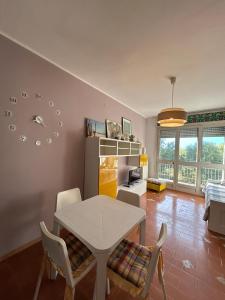 Una sala de estar con una mesa y sillas blancas. en Appartamento Marina Julia, en Marina Julia