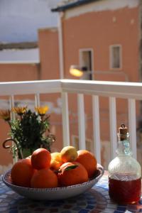 a bowl of oranges on a table next to a bottle at Casa Beretta in Pozzallo