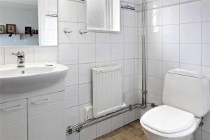 a white bathroom with a toilet and a sink at OGO503-Borghamn-Hovanaesvaegen-29-B in Borghamn +10 photos