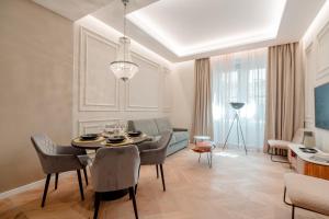 a living room with a table and chairs and a couch at Palazzo Panfilli Central Luxury in Trieste