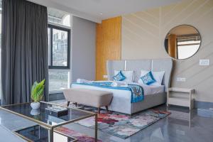 Un dormitorio con una cama, un espejo y una mesa. en The Uptown Kingdom Luxury Homestay, en Mukteshwar