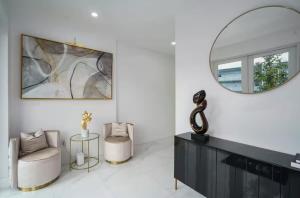 sala de estar con espejo y silla en New Construction Villa 2 min Walk to Beach Jacuzzi, en Pompano Beach 17 fotos más