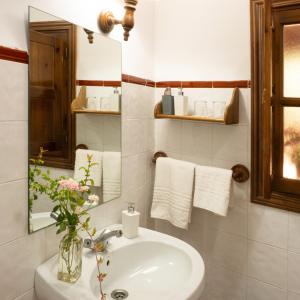 a bathroom with a sink and a mirror and towels at Hotel rural El Jardin del Conde in Puerto de Béjar