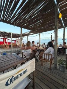 un grupo de personas sentadas en mesas en una cubierta en Departamento frente al mar Sauce Grande REFUGIOS DEL SAUCE, en Monte Hermoso