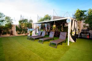 MéntridaにあるVilla del sol - piscina climatizadaの芝生の天蓋の下の椅子