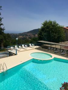 una grande piscina con terrazza e sedie di Hotel Villa Selene a Lanusei