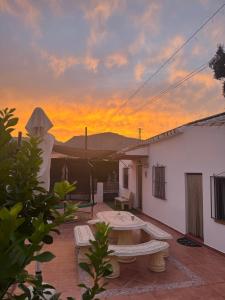 Un patio con una mesa y una puesta de sol al fondo. en Casa el Mure, en Ronda