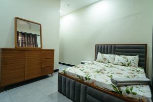 ein Schlafzimmer mit einem Bett, einer Kommode und einem Spiegel in der Unterkunft Entire house - all rooms AC - close to beach - washingmachine in Daressalam + 8 Fotos