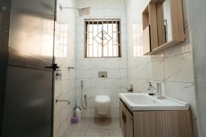 ein Badezimmer mit Toilette und Waschbecken und einem Fenster in der Unterkunft Entire house - all rooms AC - close to beach - washingmachine in Daressalam