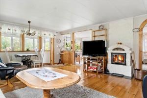 a living room with a table and a fireplace at BOH662-Roennaeng-Tuveslaettsvaegen-3 in Stansvik