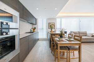 a kitchen and living room with a table and chairs at Urban Retreat 2BR Condo with Stunning City View in Vancouver