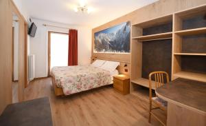 a hotel room with a bed and a desk at Hotel Stella in Passo del Tonale