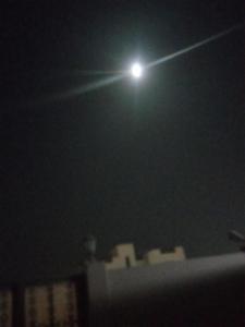 Una luna en el cielo sobre una ciudad por la noche en Holiday villa, en Ghayathi