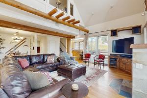 Una sala de estar con un sofá de cuero y un televisor. en Saddle Ridge Townhome I-5, en Big Sky