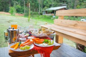 a table with plates of food on a bench at Espaço Gata Mourisca in Camanducaia
