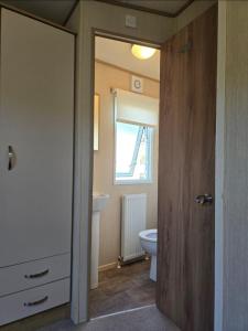 a bathroom with a toilet and a sink at 8 birth Diamond rated Caravan, en-suite, with decking at Parkdean resorts, Southview holiday park in Winthorpe