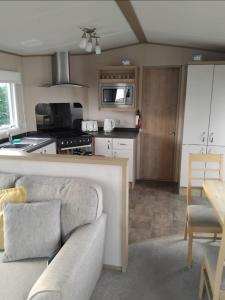a living room with a couch and a kitchen at 8 birth Diamond rated Caravan, en-suite, with decking at Parkdean resorts, Southview holiday park in Winthorpe