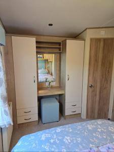 a bedroom with a bed and a desk and a mirror at 8 birth Diamond rated Caravan, en-suite, with decking at Parkdean resorts, Southview holiday park in Winthorpe