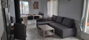 a living room with a couch and a table at Charmante petite maison in Torcenay