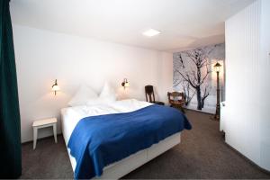 a bedroom with a large bed with a blue blanket at Hinter den Spiegeln in Heimbach +53 photos