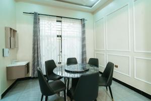 a dining room with a glass table and chairs at Entire house - full AC - beach close in Dar es Salaam