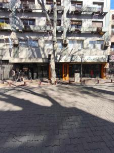 a building with a tree in front of it at Apartment in the heart of the city in Mendoza