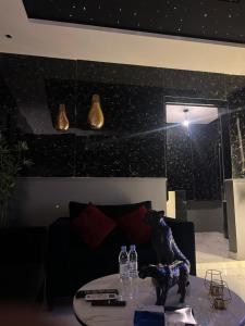 a living room with a couch and a table with bottles on it at غرفة وصالة بالدرعية in Riyadh