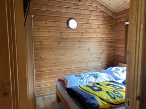een bed in een houten kamer met een houten muur bij Das Haus Kaninchenhöhle in Dankern +16 foto's