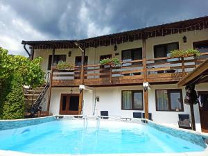 a swimming pool in front of a building at Casa Rodica in Dubova