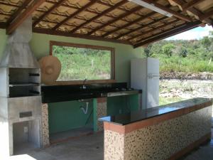 a kitchen with a stove and a counter top at Jardim dos Sonhos in Santo Antônio do Leite