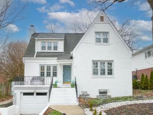 a white house with a blue door at Roomy Oasis DC area pet friendly in Takoma Park