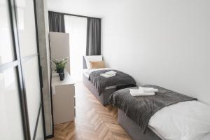 two beds in a small room with a mirror at Apartamenty Laura in Kostrzyn nad Odrą